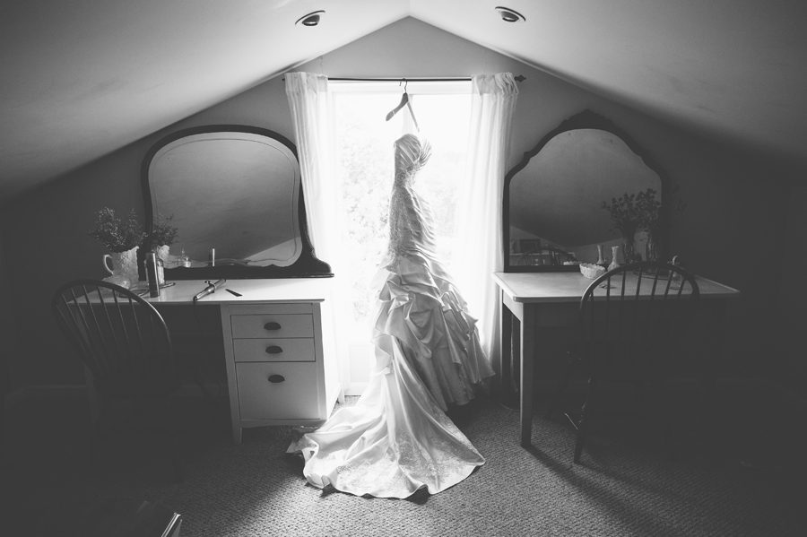 black and white image of satin dress hanging in the window {elburn wedding photographer}