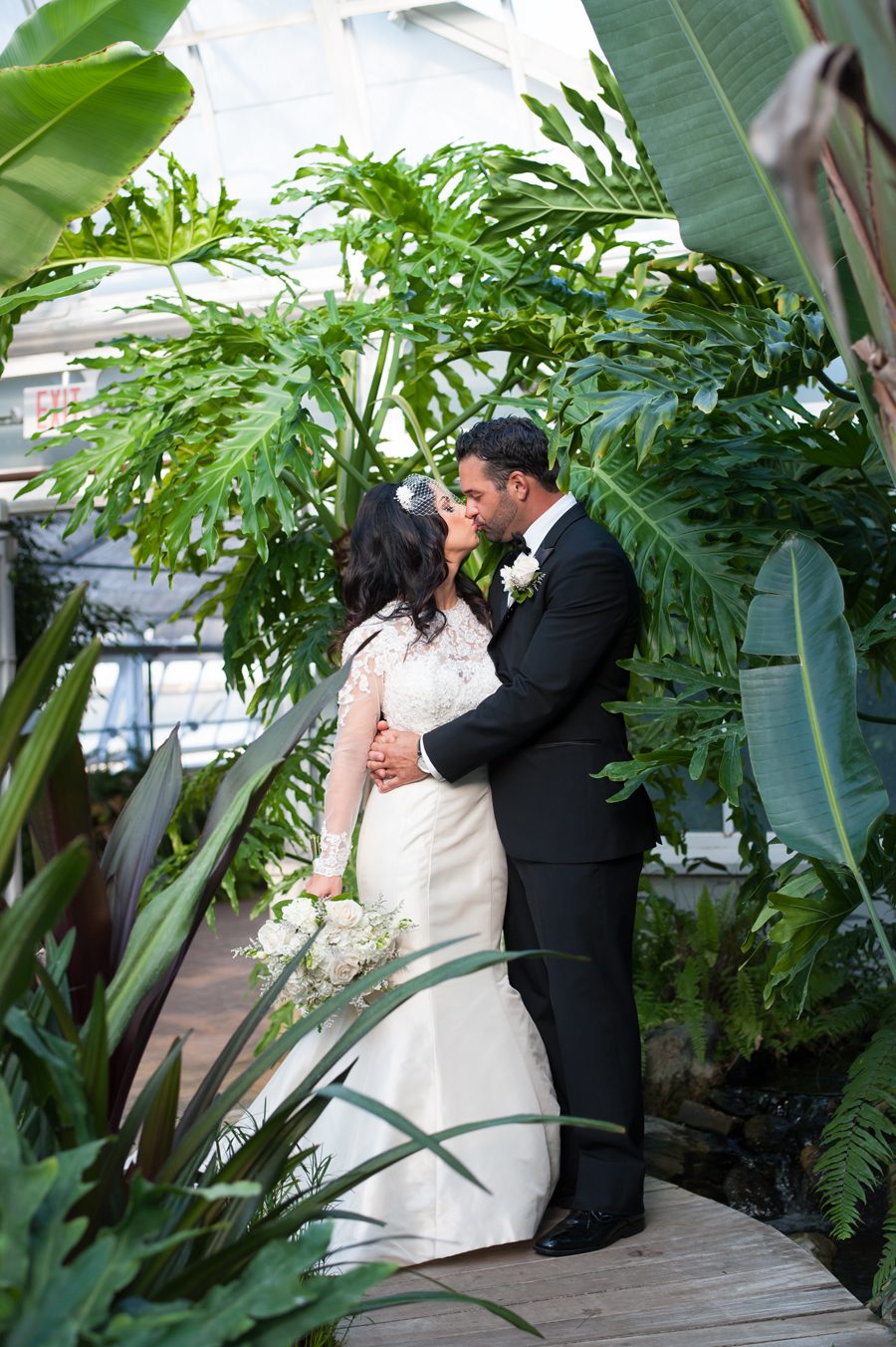 bride and groom kissing in greenhouse {joliet wedding photographer}