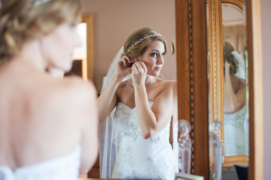 bride putting her earrings in {elite photo} batavia wedding photographer