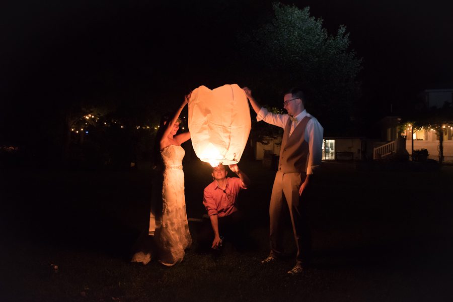 wish lanterns being lit at the wedding reception {heritage prairie farm photography}