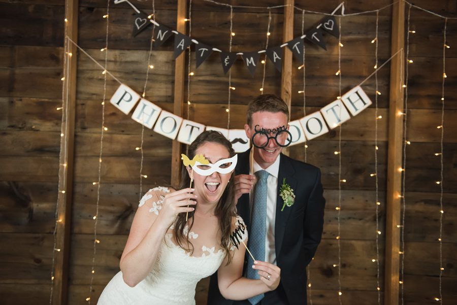 bride and groom in their photo booth in the barn
