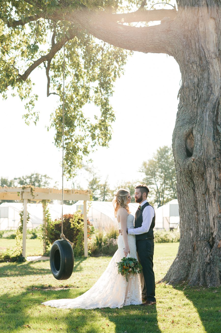 bride and groom by the tire swing - farm wedding