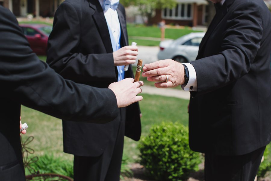 Groomsmen getting ready and having cigars.