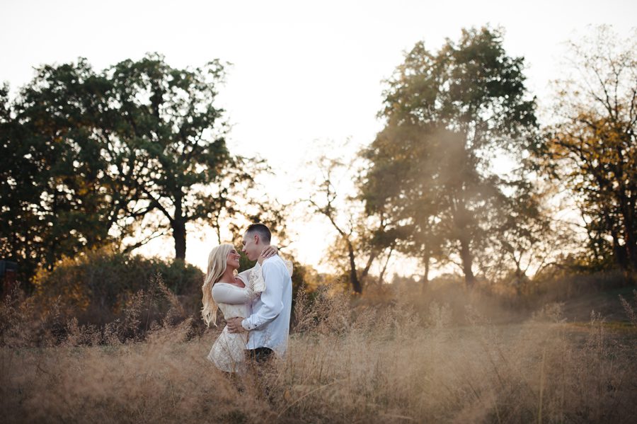 hugging in the tall grass with sun flare